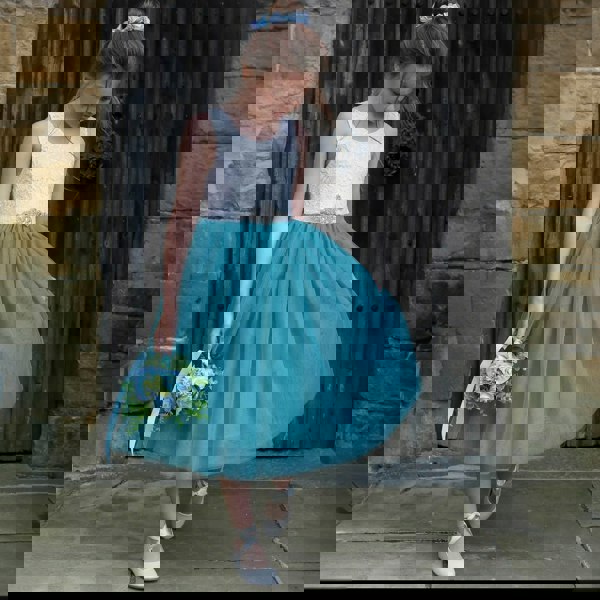 young girl looking at the floor stood in doorway
