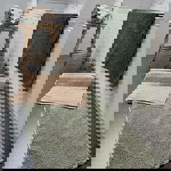 Organic cotton bath mats in neutral colours - sage green, khaki and beige.