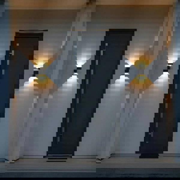 black up and down outdoor wall light mounted either side of the front door of a modern home 