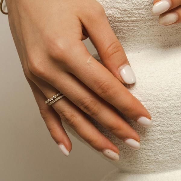 The BLOOMTINE Illuminess™ Combi Ring in gold vermeil. This innovative 2-in-1 design fuses a pavé band with a bezel-set moissanite ring, offering a perfectly styled stack with a single, comfortable fit and extraordinary cosmic fire. modelled on elegant ladies hand