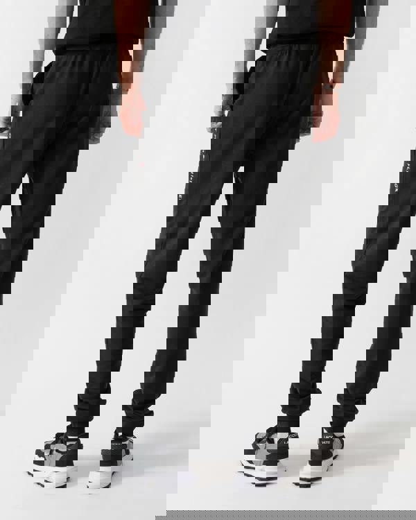 back shot of a model wearing Tommy Hilfiger Mens Track Joggers in Black