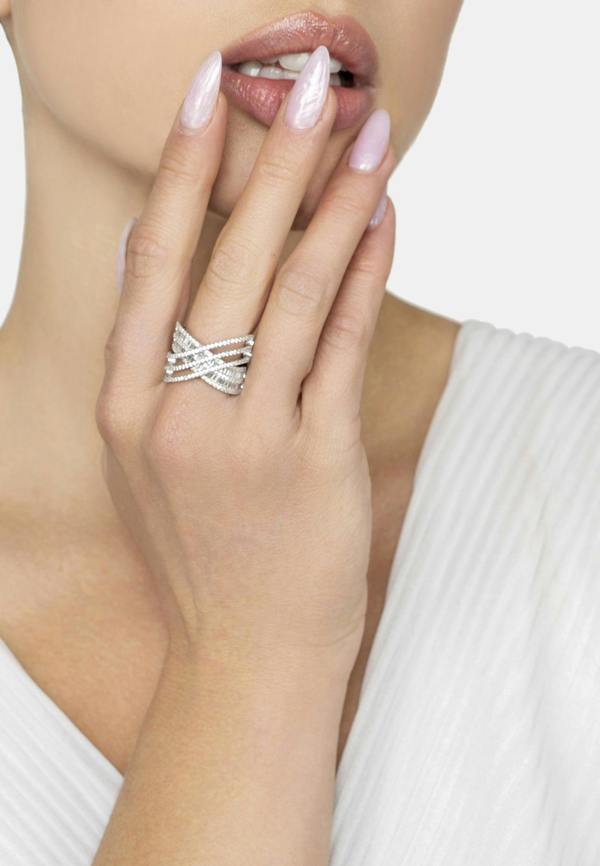 Silver ring on a model's finger with a plain background