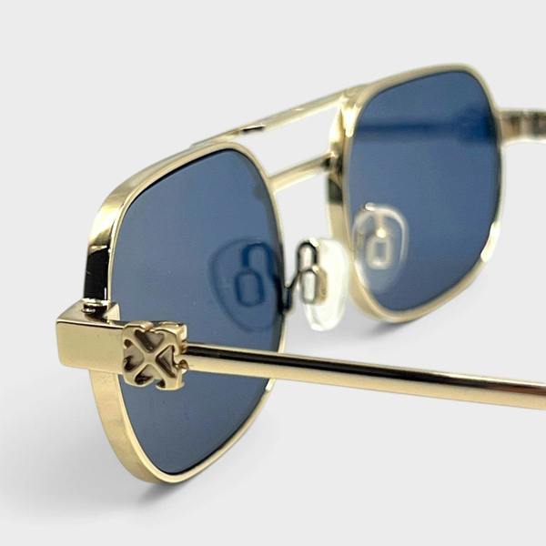 Supplied Fashion Baltimore Arrow sunglasses featuring a silver frame, blue tinted lenses, and signature arrow detail.