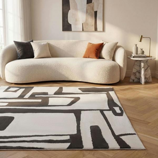 Modern living room with a white sofa, abstract rug, and decorative items.