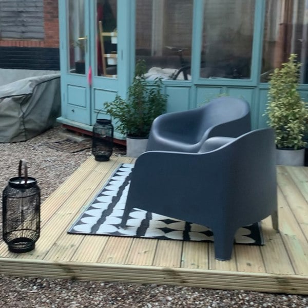 Outdoor seating area with chairs and lantern on deck