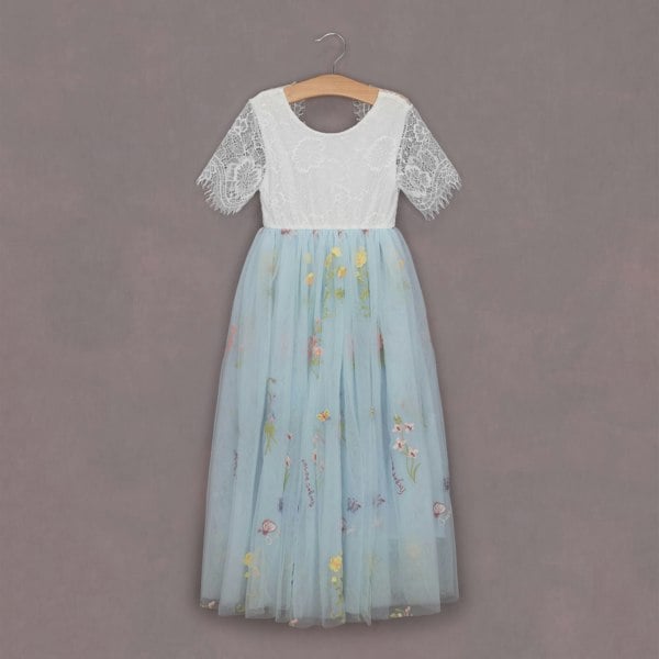 Two-tone dress with lace top and floral skirt on a hanger against a gray background