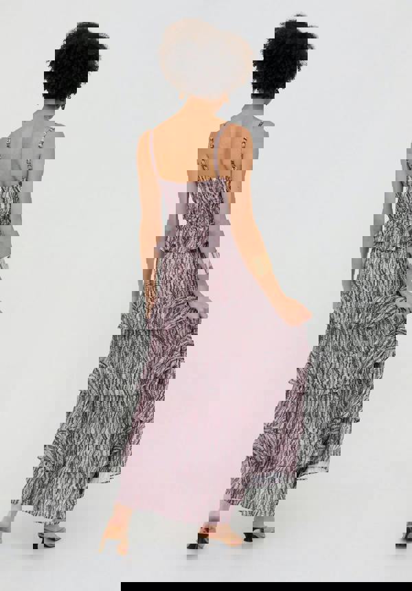 Woman wearing a tiered dress with a zebra print pattern on a white background