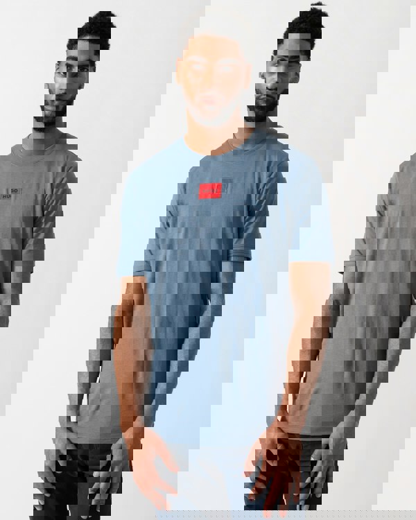 Model wearing a HUGO Diragolino212 Label Logo Mens T-Shirt in Open Blue