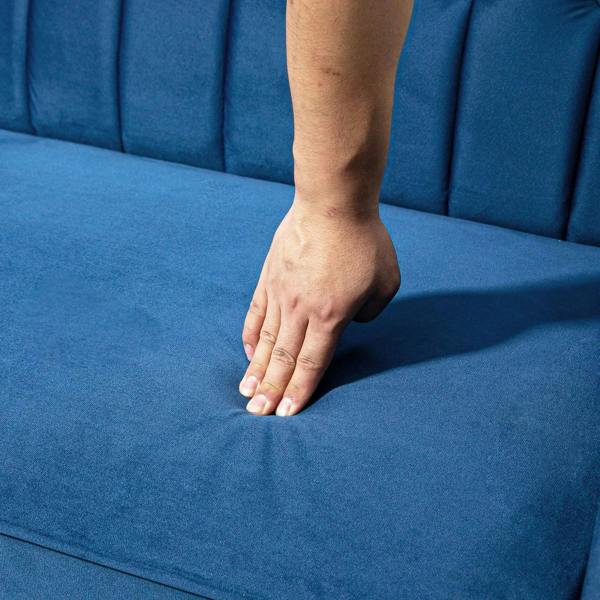 Blue sofa bed split seat cushion with hand pressing, indicating soft upholstery
