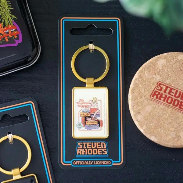 Gold metal keychain with square charm, shown on Steven Rhodes card packaging.