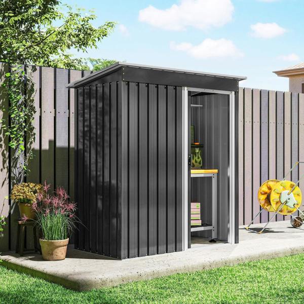 Black metal garden storage shed with sliding door closed, sloped roof and ridged siding.