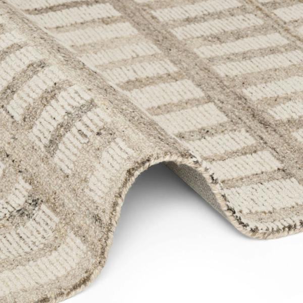Close-up of a textured beige and white checkered rug corner.