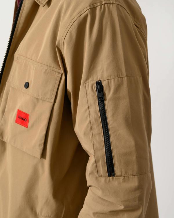 close up shot of a model wearing a HUGO Emmond Mens Zip Overshirt in Beige Overflow 928