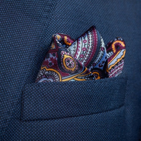 Intricate paisley design silk pocket square in blue, burgundy & gold by Otway & Orford folded in top pocket