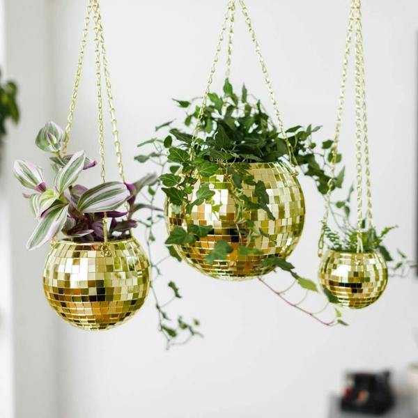 Three hanging gold disco ball planters of varying sizes, filled with lush trailing green houseplants against a white background.