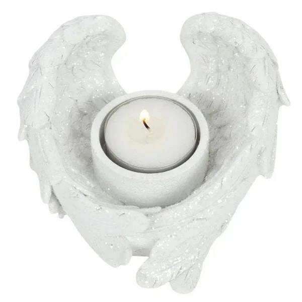 White glitter angel wing candle holder with lit round tealight in center