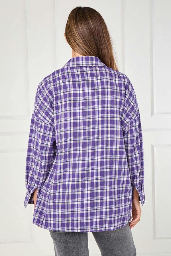 Person wearing a purple plaid shirt against a white background