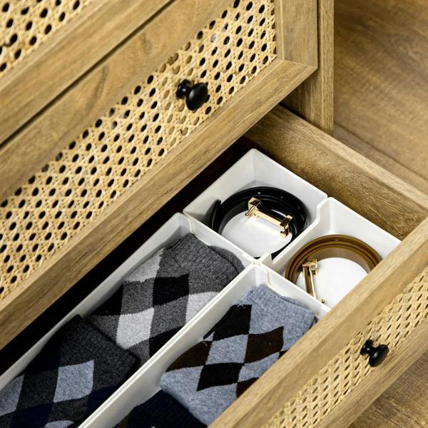 Wood-effect cabinet with open drawer showing rattan front, folded fabric and small accessories