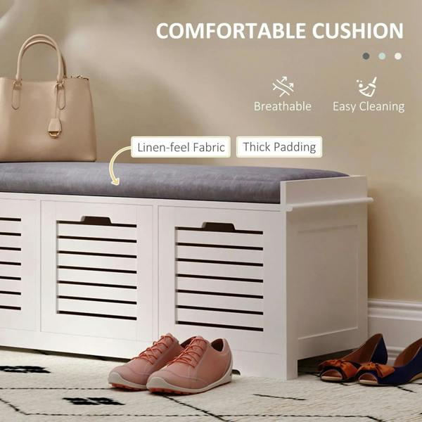 White shoe storage bench with gray cushion and slatted drawer fronts with shoes