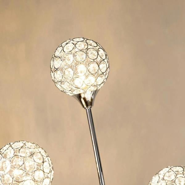 Close-up of round crystal ball lampshade on a chrome floor lamp arm