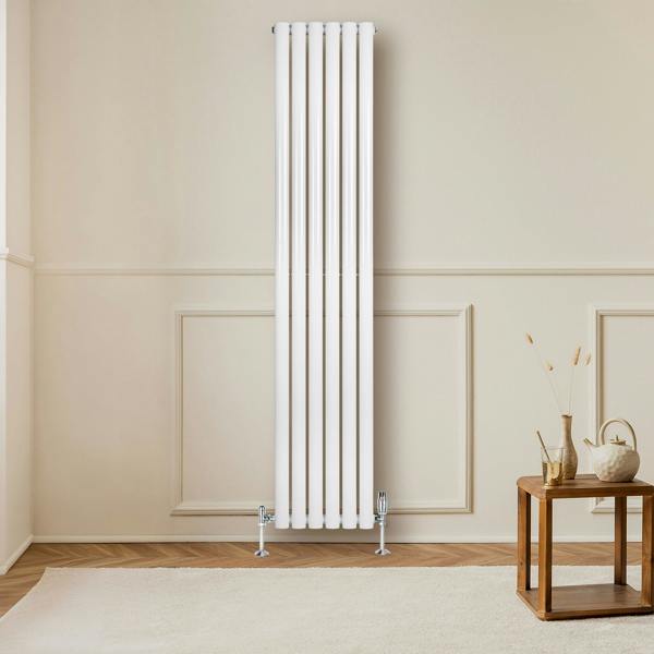 Sleek white oval single column radiator, 1800mm x 360mm, mounted on a wall, complemented by stylish valves and a cozy interior setting