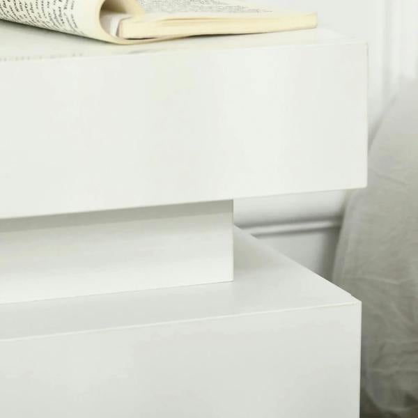 Close-up of white high-gloss drawer front on a two-drawer bedside table
