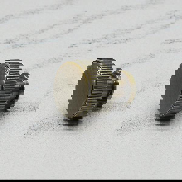 An antique brass reeded round knob