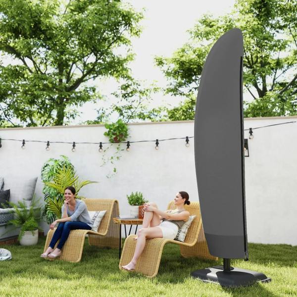 Black cantilever umbrella cover on base in backyard patio garden