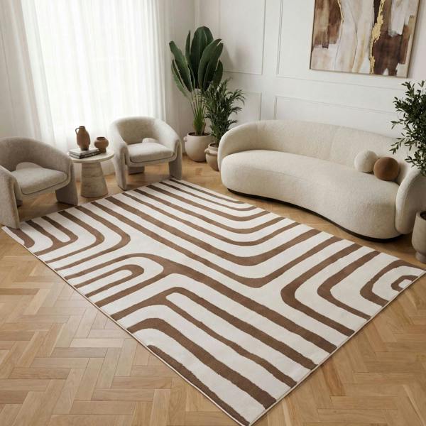 Living room with a patterned rug, beige sofa, and decorative plants.