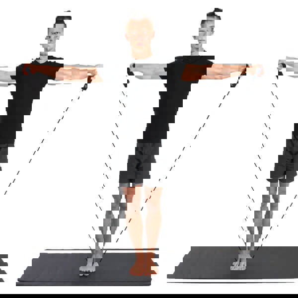 Man standing on an exercise mat exercising with a Fitness Mad resistance tube