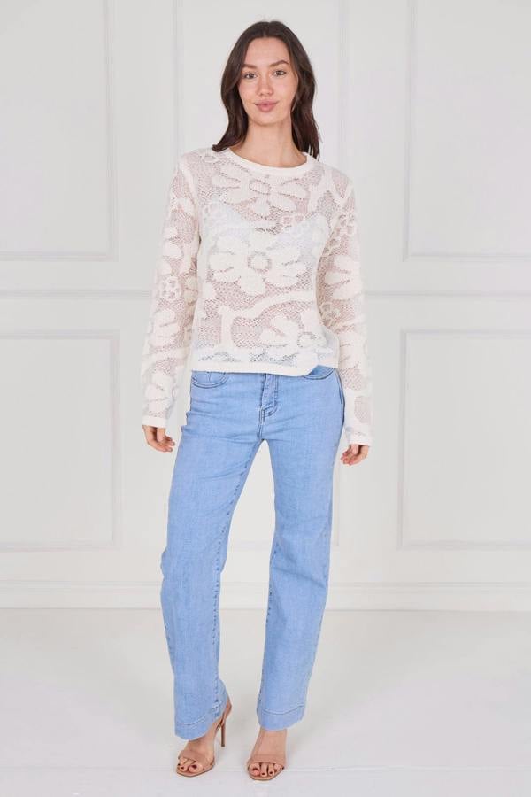 Model wearing a long sleeve crochet top with an open-knit pattern, styled with high-waisted jeans, featuring a relaxed fit and lightweight texture for casual everyday wear.