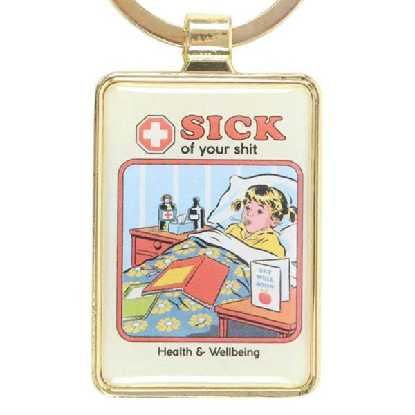 Close-up square gold keychain charm: “SICK of your shit” and “Health & Wellbeing” artwork