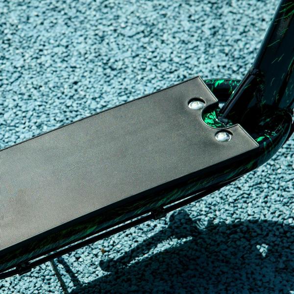 Non-slip black footplate on a green kids kick scooter deck with metal mounting