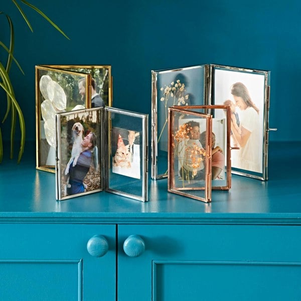 Four metal picture frames on cabinate