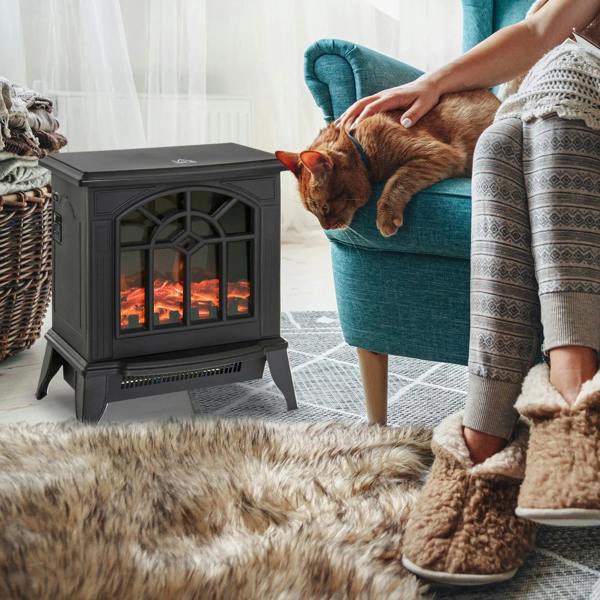 Black electric fireplace heater stove near a blue chair and rug, with LED flame window lit.