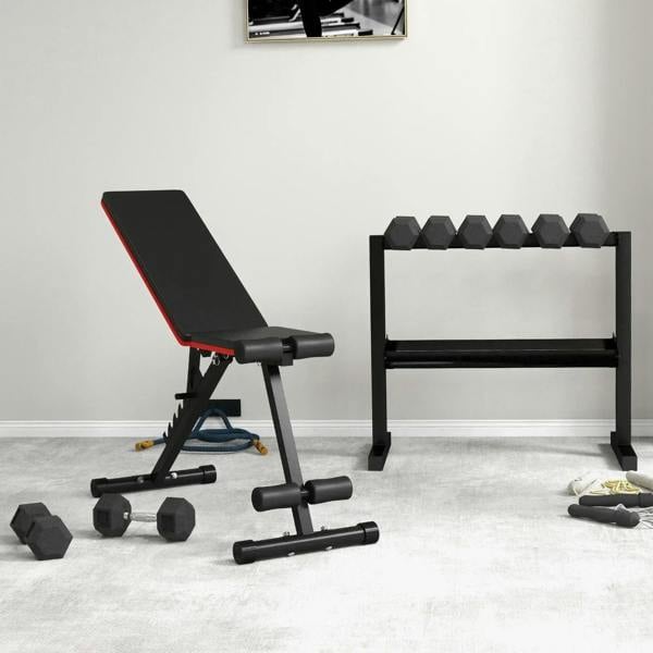 Hex rubber dumbbells on the floor with weight bench in a home gym setup