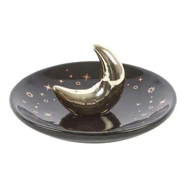 Gold crescent moon incense holder on dark tray with star designs
