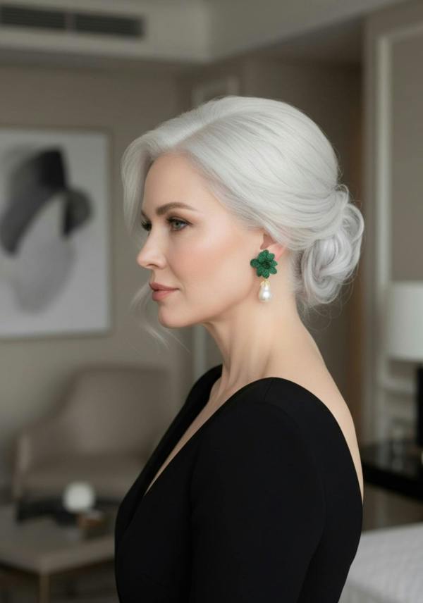 Woman with styled hair wearing green earrings with pearl drops