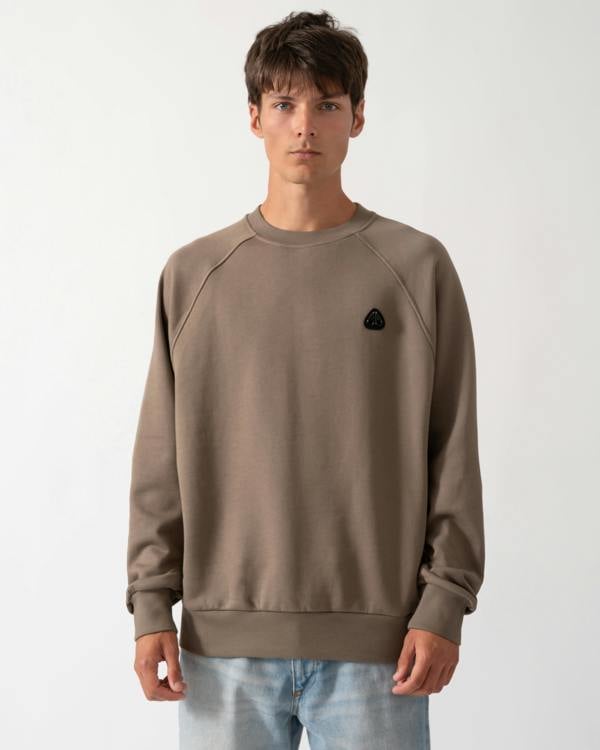 model wearing a Moose Knuckles Mens Yul Crewneck Sweatshirt in Ashen 1968