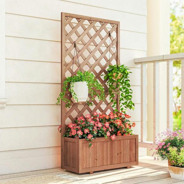Tall wooden planter with lattice trellis and blooming flowers in raised bed, brown
