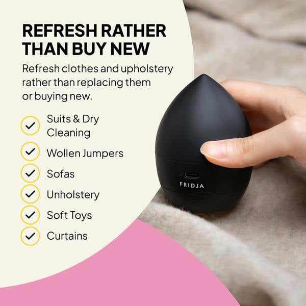A hand holds the black Fridja Commercial Garment Care Duo – f1600 Steamer & f40 Fabric Shaver on a beige blanket, showing how you can refresh clothes and upholstery like suits, jumpers, sofas, or curtains instead of replacing them.