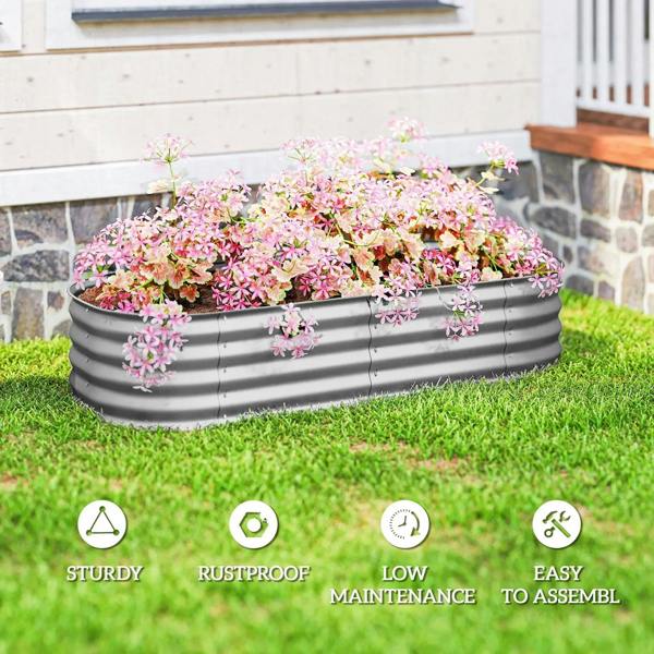 Gray galvanized metal raised garden bed with pink flowers on a lawn