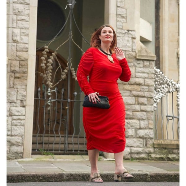 Women's Red Plus Size Boudicca Bodycon Midi Dress styled with quartz jewelry by Veronique Designs, black clutch, and gold Kurt Geiger sandals.