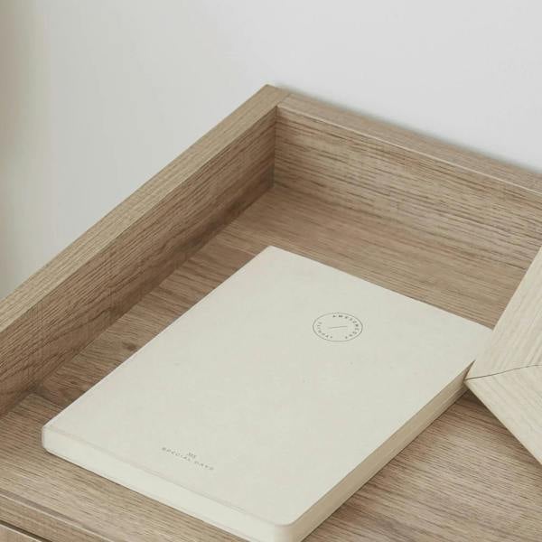 Open drawer interior with light natural wood sides and white bottom tray