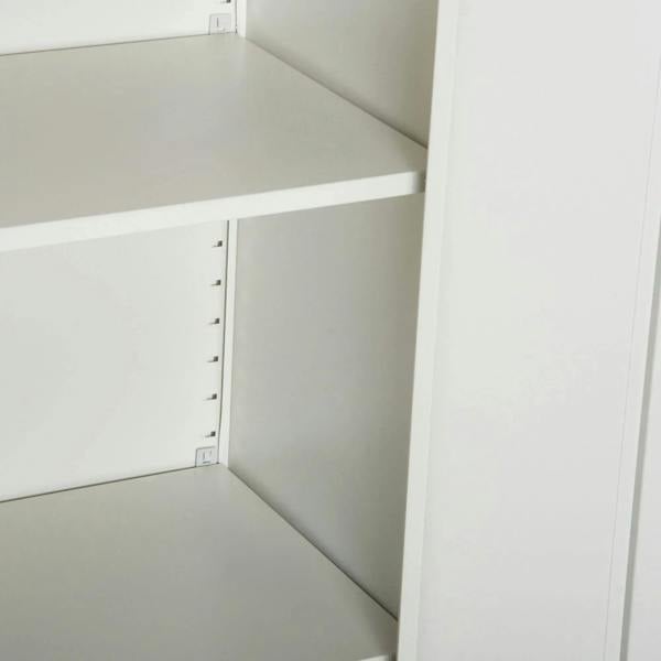 Open white filing cabinet interior with adjustable shelf mounting holes and rails.
