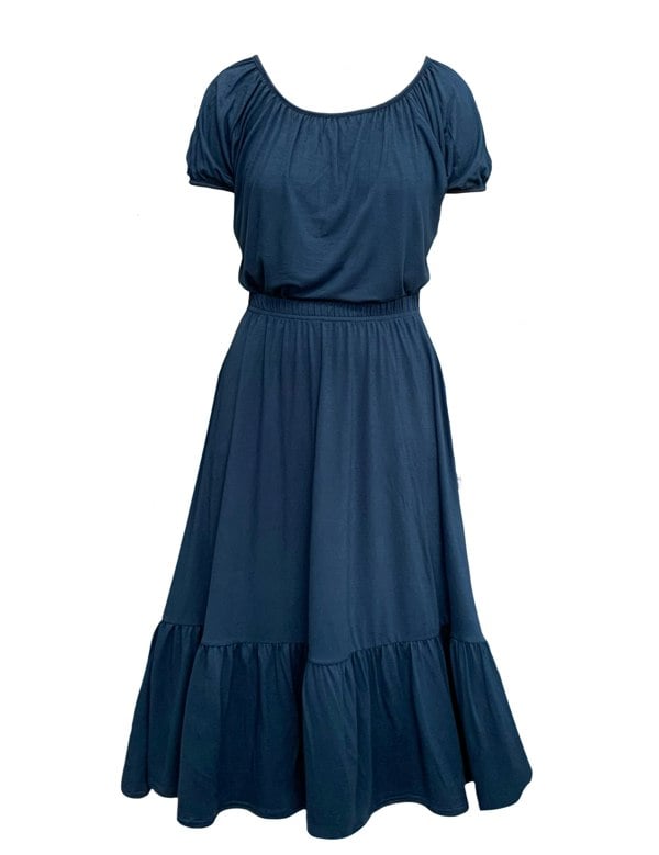 This is a french navy jersey skirt silhouetted against a white background. The skirt has a gathered elasticated waist and deep gathered hem frill. This is a front veiw and tucked in to the skirt is a top in the same colour. It is a loose shape and has short gathered sleeves.