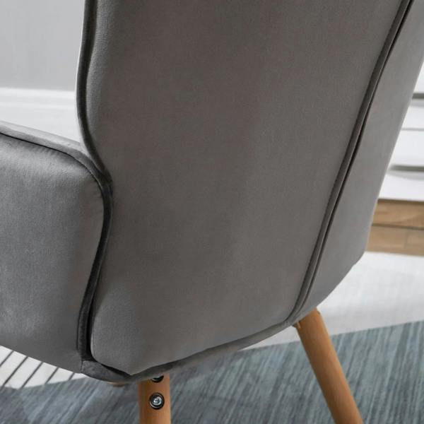 Grey upholstered wingback chair side panel with curved arm and visible wooden leg