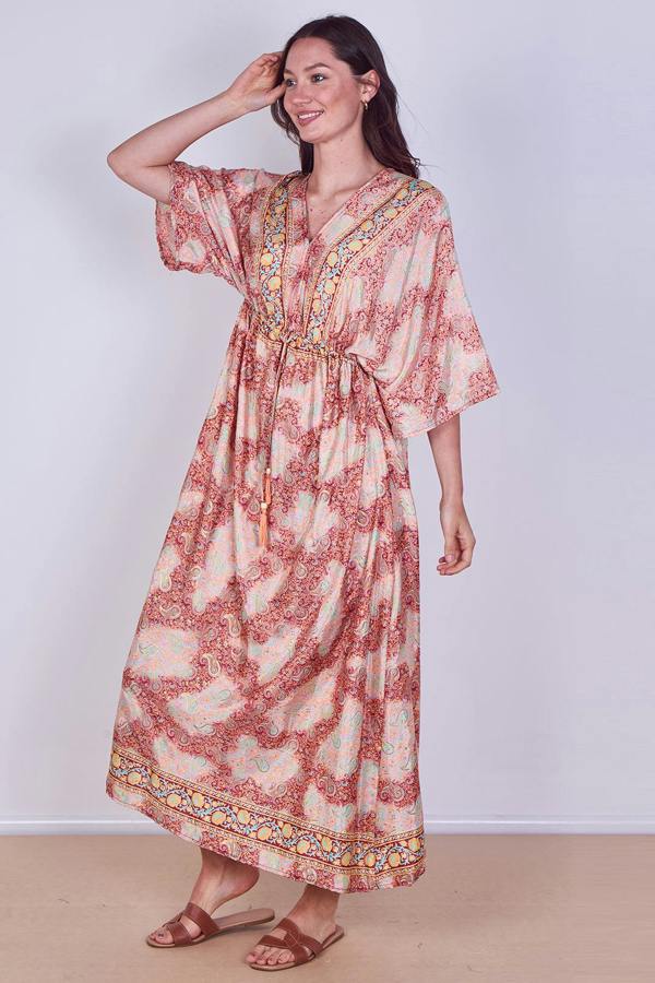 Woman wearing a patterned dress against a plain background