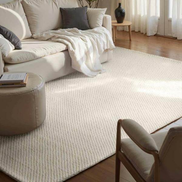 Living room with a beige sofa, rug, and armchair.