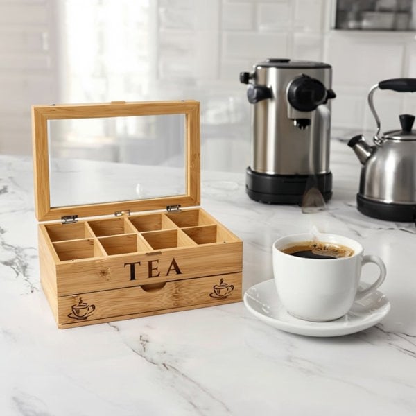 Wooden tea box with compartments on a kitchen counter next to a cup of coffee.